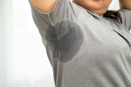 Sweaty underarms, Asian woman with sweat on clothes under armpit.