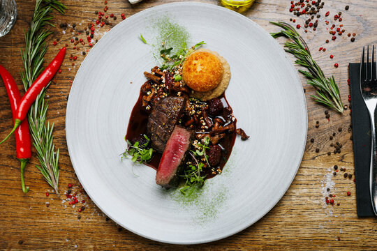 Medium rare venison steak with chanterelles and berry sauce
