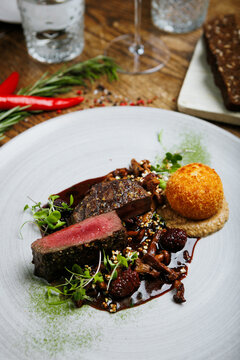 Medium rare venison steak with chanterelles and berry sauce