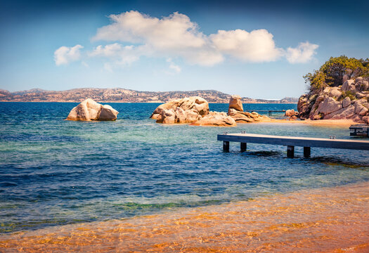 Spectacular summer scene of public beach of Rafael port with wooden pier, Province of Olbia-Tempio, Italy, Europe. Adorable morning view of Sardinia. Nice seascape of Mediterranean sea.