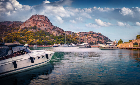 Attractive summer view of Poltu Quatu port with luxury yacht and motorboat. Amazing morning scene of Sardinia island, Italy, Europe. Picturesque Mediterranean seascape. Traveling concept background.