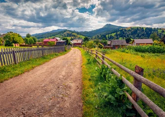 Empty dirt road in the mountain countryside. Picturesque summer view of Carpathian mountains, Ukraine. Superb morning scene of Stebny mountain village. Beauty of countryside concept background. © Andrew Mayovskyy