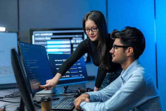 Two Developers Reviewing Code On Monitor In Tech Office