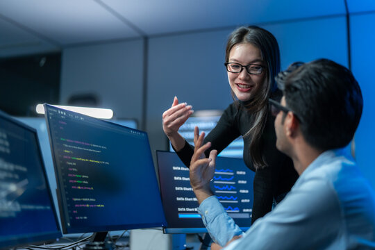 Developers Discussing Software Project In Dark Office