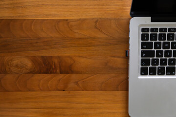 Ordinateur portable sur bureau en bois avec large espace de copie © Romain