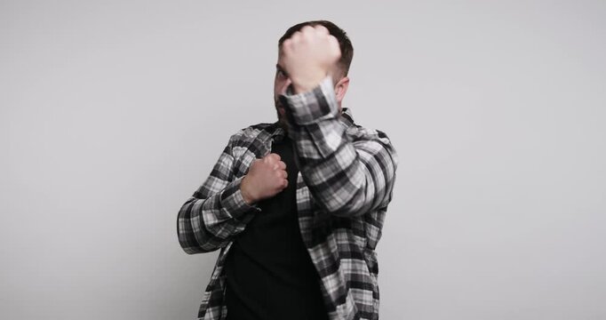 Man practices boxing moves indoors in a simple room