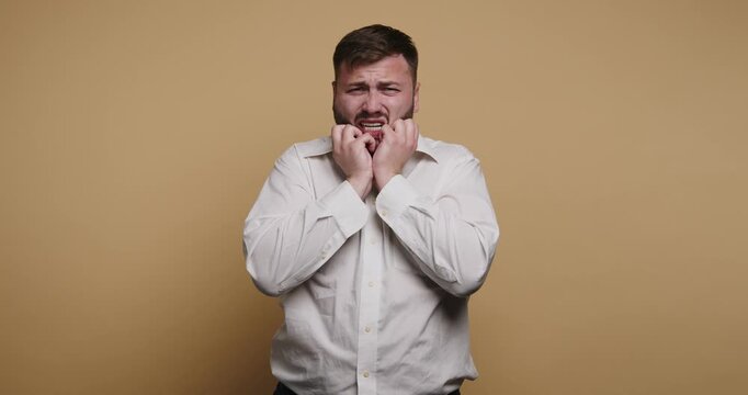 Expressions of discomfort in a studio setting with a man in a white shirt acting out feelings