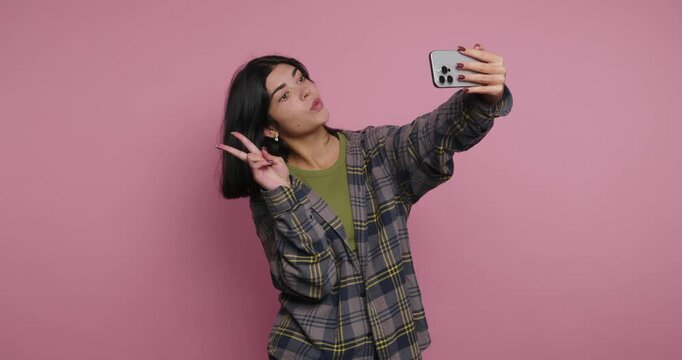 Taking selfies in a pink room with different poses and expressions by a young person throughout the day