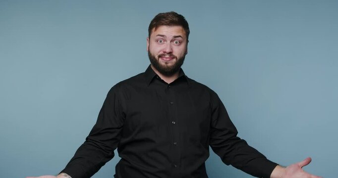 Man shows different facial expressions on a plain background during a performance at a studio in the afternoon