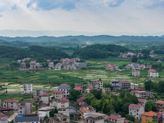 Fototapeta premium Aerial view of rural houses and green pastoral scenery