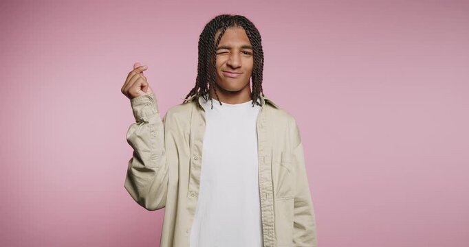 Person shows different hand signs and expressions about love in a studio with pink background