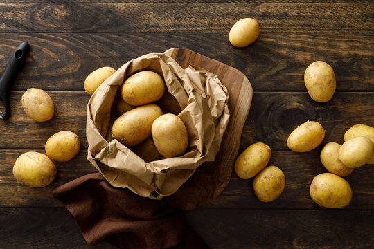 Fresh raw whole potatoes on rustic wooden table, top view