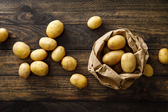 Fresh raw whole potatoes on rustic wooden table, top view