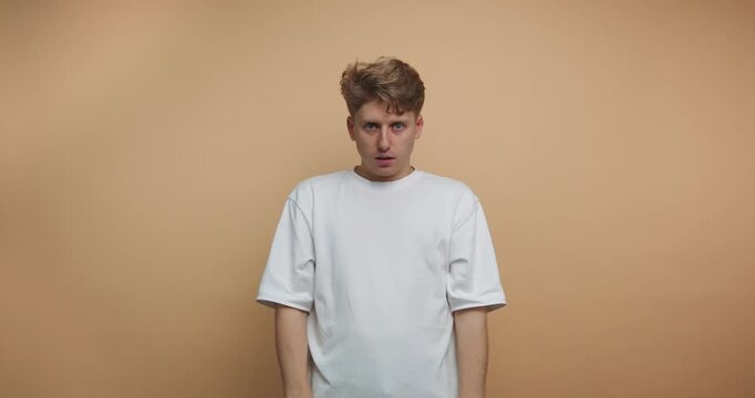Man shows different emotions in front of a plain background in a short series of expressions and changes in demeanor
