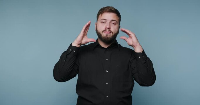 Person signs using hand movements in front of a blue background at a studio setting
