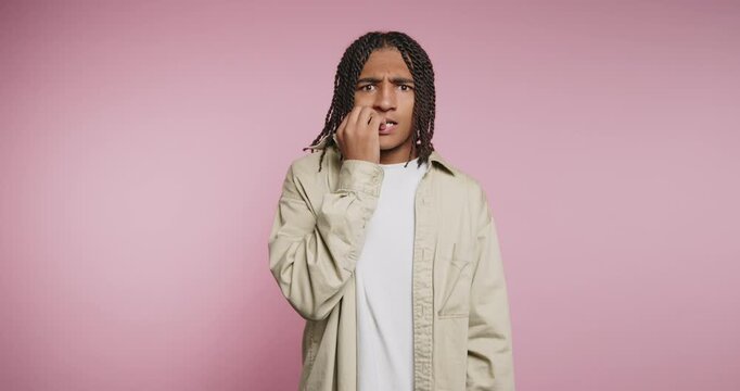 Watching a person react with surprise and confusion in a studio with a pink background
