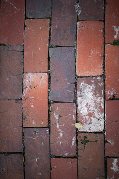 Weathered red brick pathway pattern closeup