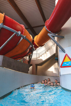 Large group of happy clients and families swimming down a lazy river stream at an indoor water park