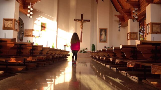 ZAKOPANE, POLAND - NOVEMBER 8 2018: Girl in a red jacket walking inside the Holy Cross Church in Zakopane.