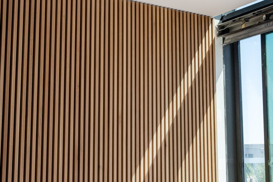Mur beige orang&eacute; textur&eacute; avec lignes verticales et un trait de lumi&egrave;re diagonal cr&eacute;ant un contraste graphique et moderne.