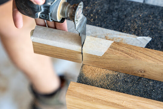 Homme coupant un b&acirc;ton de bois avec un outil, illustrant une activit&eacute; de travail manuel et de bricolage en atelier.