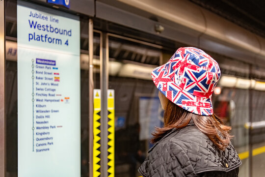 London, England: A lady wearing Union Jack hat looking at the metro map at one of the underground  stations in the British capital.