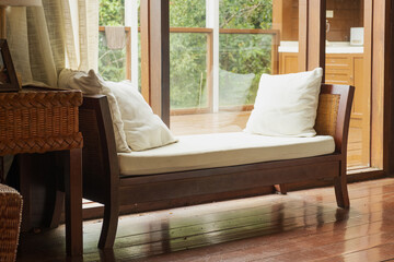 Fototapeta premium Wooden daybed with white cushions and wicker basket in tropical room