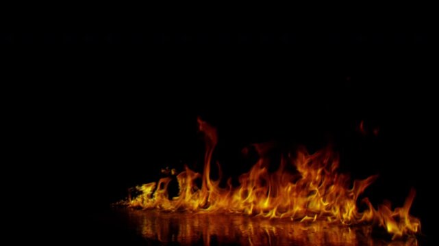 Vibrant dancing fire flames isolated on a deep black background.