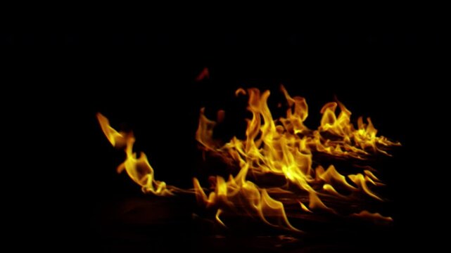 Vibrant dancing orange and yellow fire flames isolated on black background.
