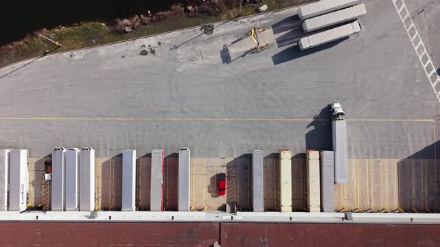 Discover the intricate workings of a modern logistics hub in Halifax, Nova Scotia, where trucks efficiently load and unload goods at bustling docks