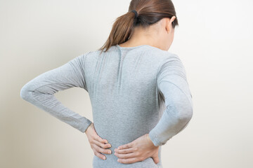 Obraz premium Pain body muscles stiff problem, asian young woman, girl painful around body ache from work hard, holding massaging rubbing waist hurt, sore. Isolated on background. Health care and medicine concept.