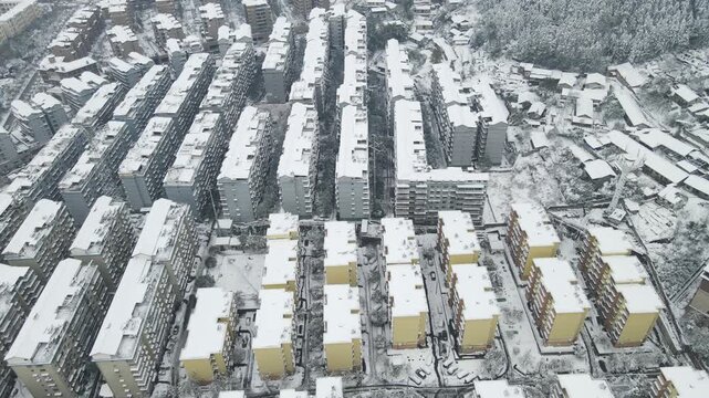 Aerial view of snow-covered apartment buildings in an urban residential neighborhood
