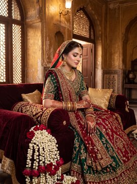Pakistani bride seated with detailed mehndi jewelry in regal portraiture