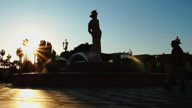 4K French Riviera Nice silhouettes of people walking around Apollo&rsquo;s fountain in place Massena