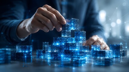 Fototapeta premium Data blockchain technology concept showing hands stacking glowing blue digital cubes on a desk