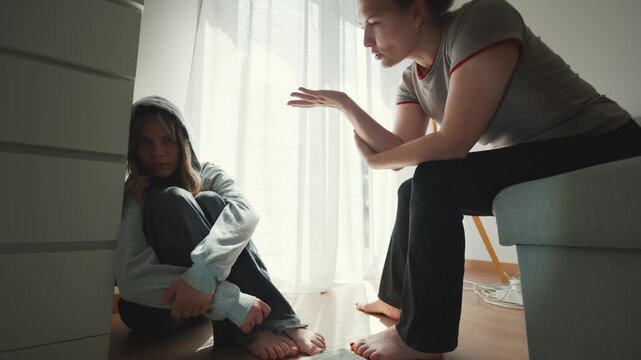 Mother scolding sad teenage daughter during conflict