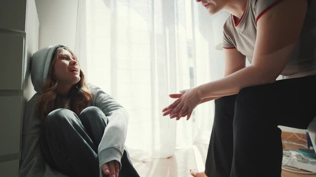 Supportive mother comforting depressed teenage daughter