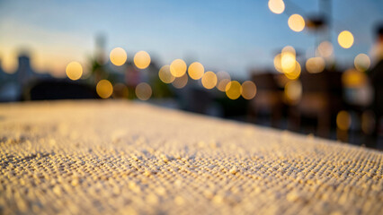Fototapeta premium Granular woven textile surface under warm golden evening bokeh