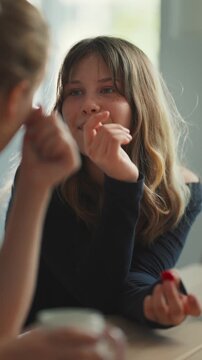 Teenage girl talking and eating berries with friend