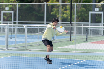 Fototapeta premium Active Diverse People Playing Pickleball on Outdoor Court