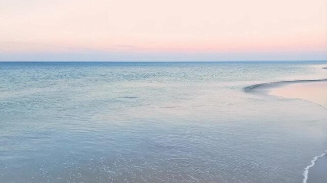 Serene beach at sunset with gentle waves lapping at the shore. A tranquil escape for relaxation and reflection