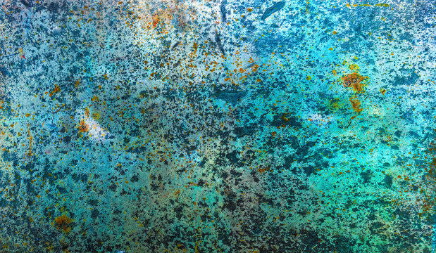 Textured surface with peeling blue paint 