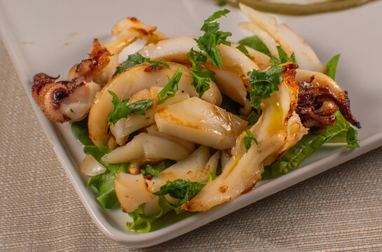 Grilled Seafood Appetizer with Greens on White Plate
