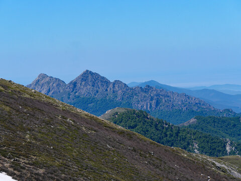 Distant view of pointed mountain peaks and Mediterranean Sea from Val d'Ese Corsica