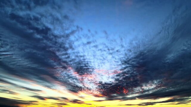 A stunning time-lapse of the transition from evening to night (twilight). Finely textured cloud formations move dynamically across the deep blue sky. 