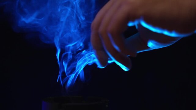 1080p 120fps slow motion of putting out a cigarette in ashtray and blowing the last smoke under blue neon light
