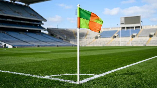 Corner flag waving on a green Gaelic football and hurling pitch in a large empty stadium