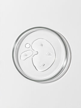 Cleansing micellar water fills petri dish with transparent bubble texture, cleansing liquid captures impurities without alcohol, cleansing formula visible through clear laboratory glass