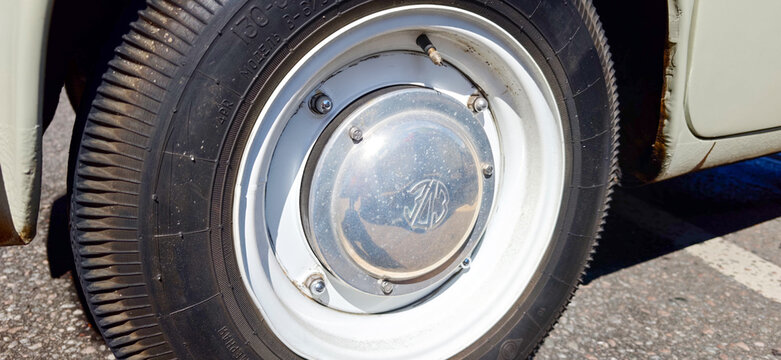 Saint Petersburg, Russia - May 23, 2026: Zaz Zaporozhets vintage car wheel with chrome hubcap and black tire parked on asphalt surface in bright sunlight