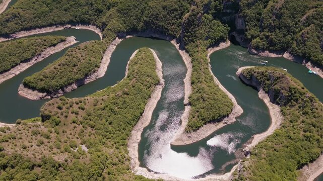 4K cinematic drone shot of the spectacular Uvac River meanders canyon in Serbia. Aerial footage of curvy river winding through deep rocky cliffs and green hills.